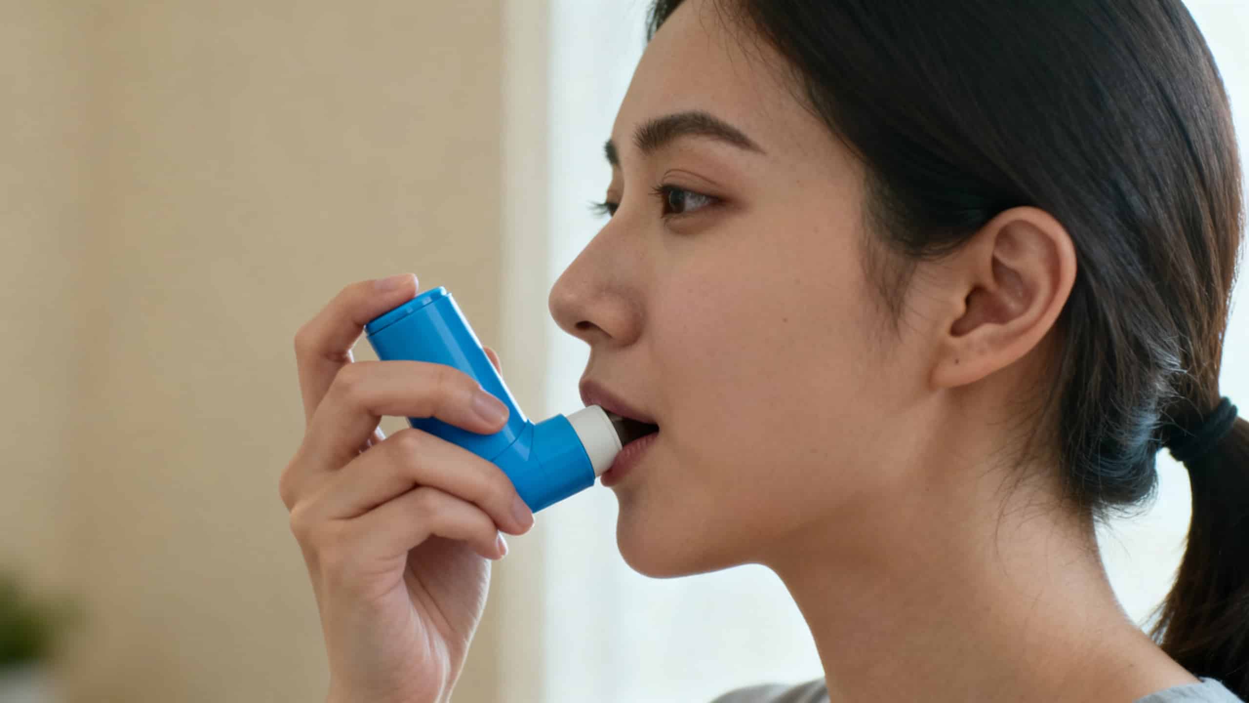 Femme utilisant un inhalateur pour traiter une crise d'asthme allergique au pollen